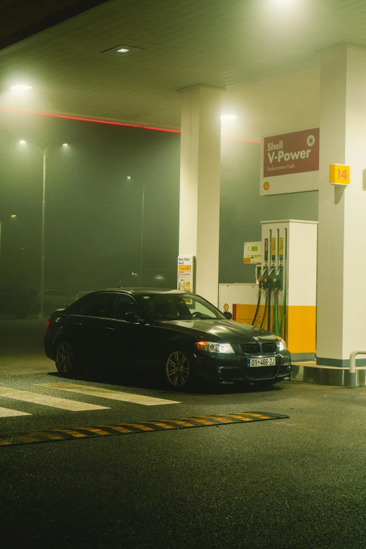 a car parked outside a gas station in the rain