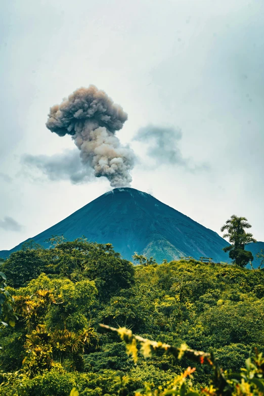 a hill that has a cloud of smoke rising out of it