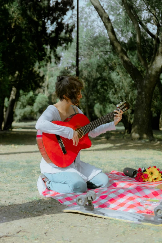 a person playing an acoustic guitar in the park