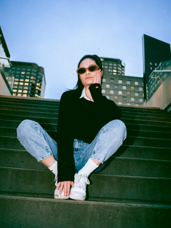 a girl sits on the steps and looks off into the distance