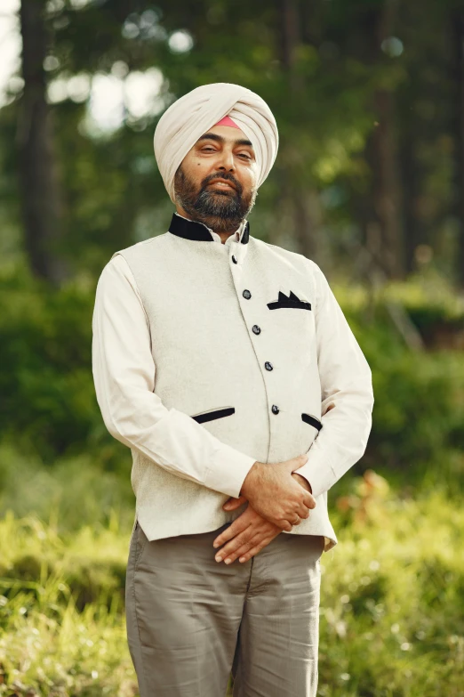 a man in turban standing by some trees