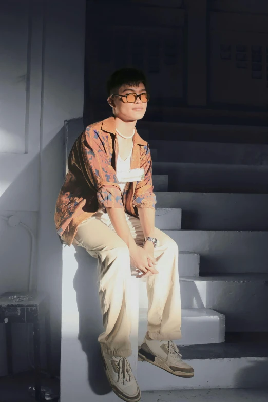 a person wearing glasses and sitting on a set of steps