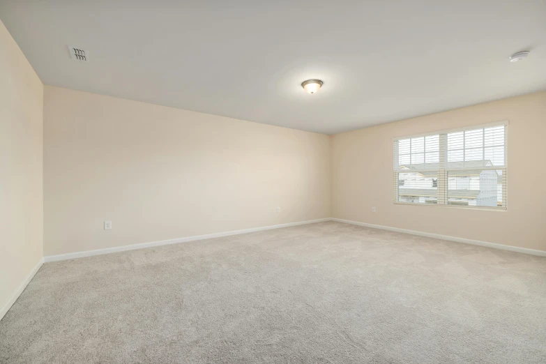 a very empty bedroom with bright windows