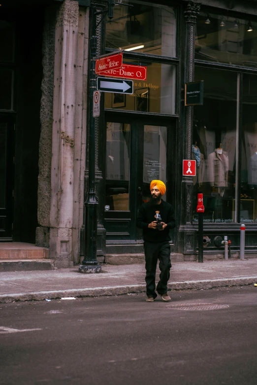 a man standing on a street corner near an old building