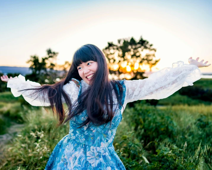 a woman in a blue dress smiles and poses