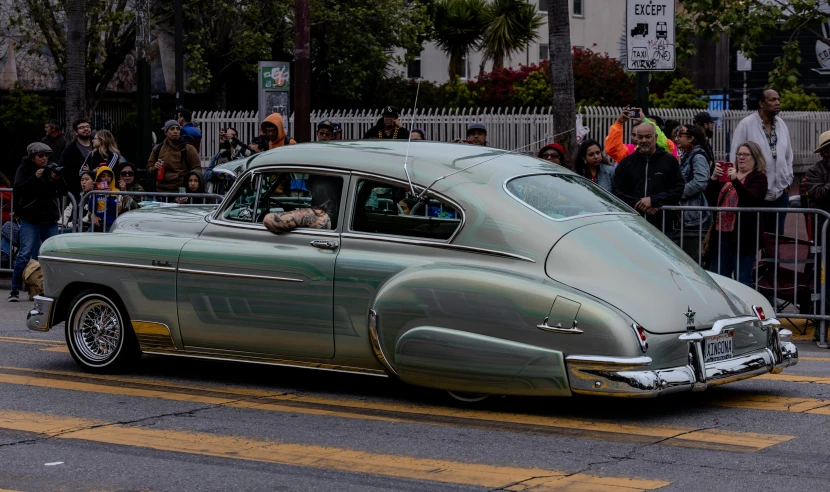 a large gray car sitting on top of a road