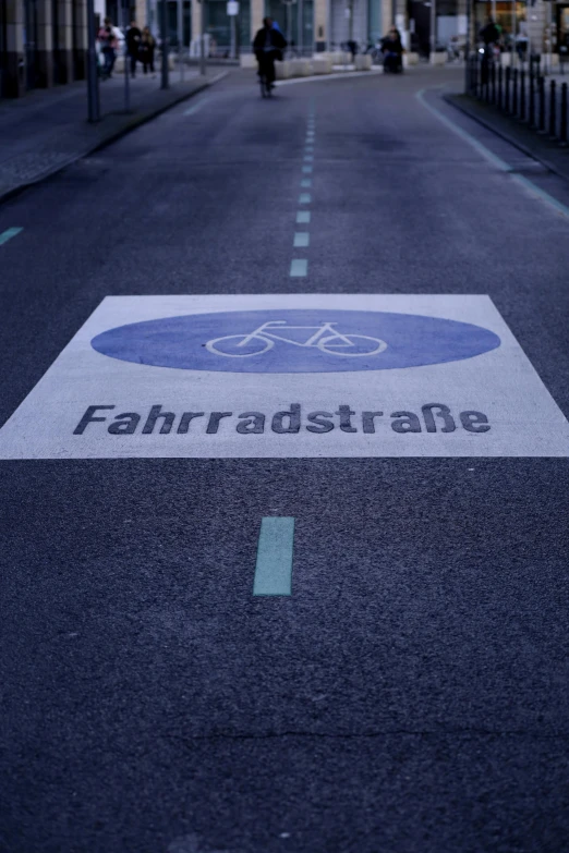 a blue and white street sign on the pavement