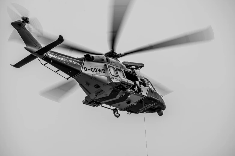 a helicopter flying through the air in a black and white po