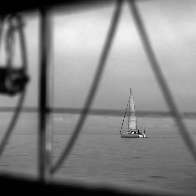 a white sail boat is in the middle of the water