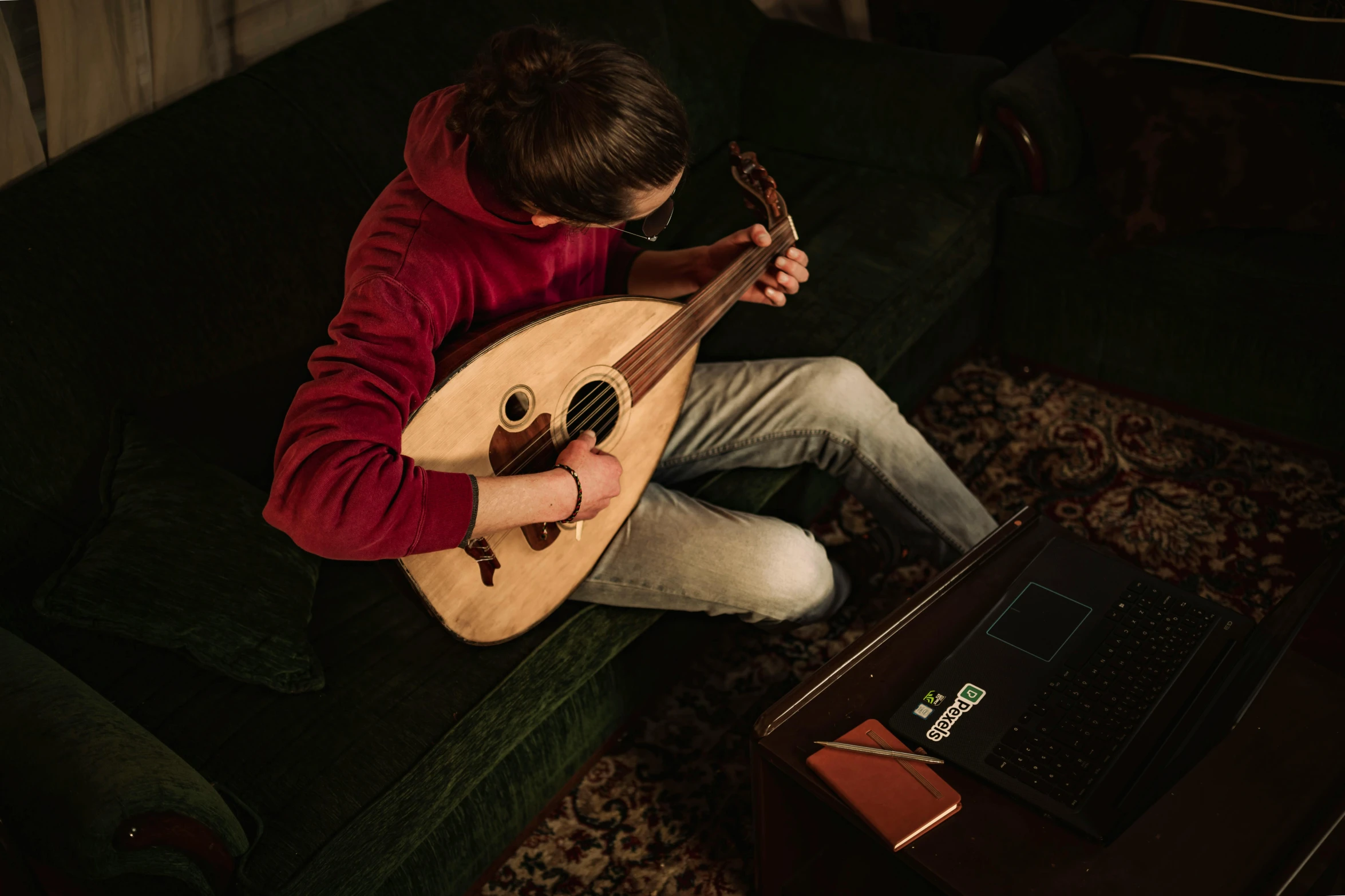 a man sitting on top of a couch holding a guitar