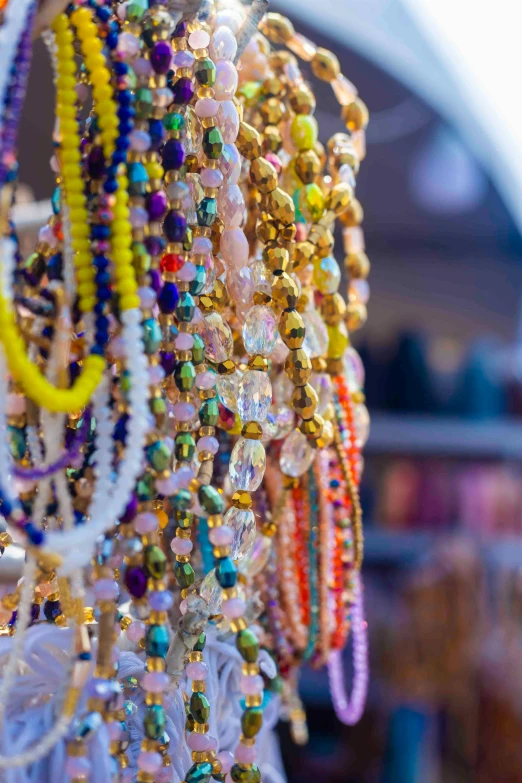 a bunch of beaded celets hanging on a rack