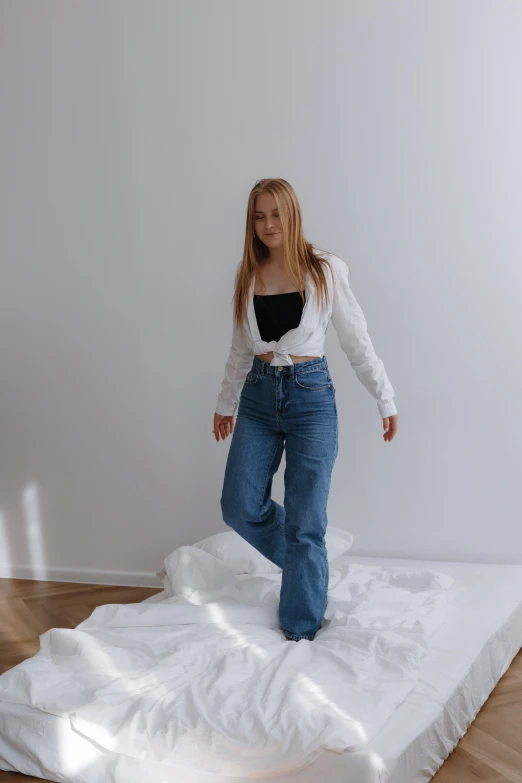 a woman wearing jeans and a white shirt posing for the camera