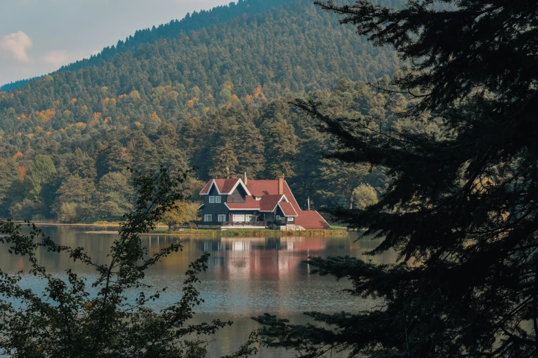 houses on the shore of a lake surrounded by green mountains