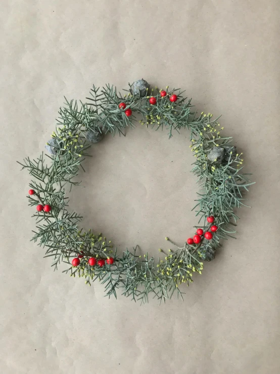 a circular wreath with small berries and leaves