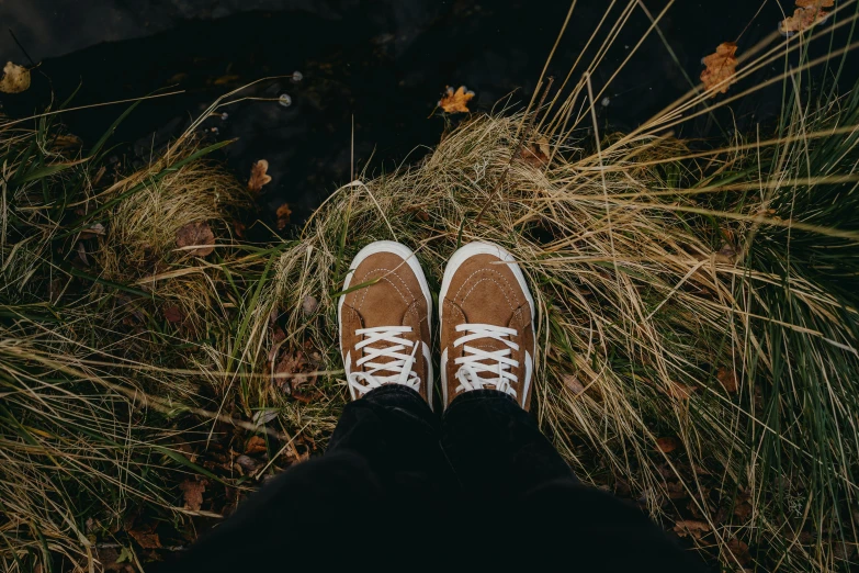 someone standing with their feet propped on the grass