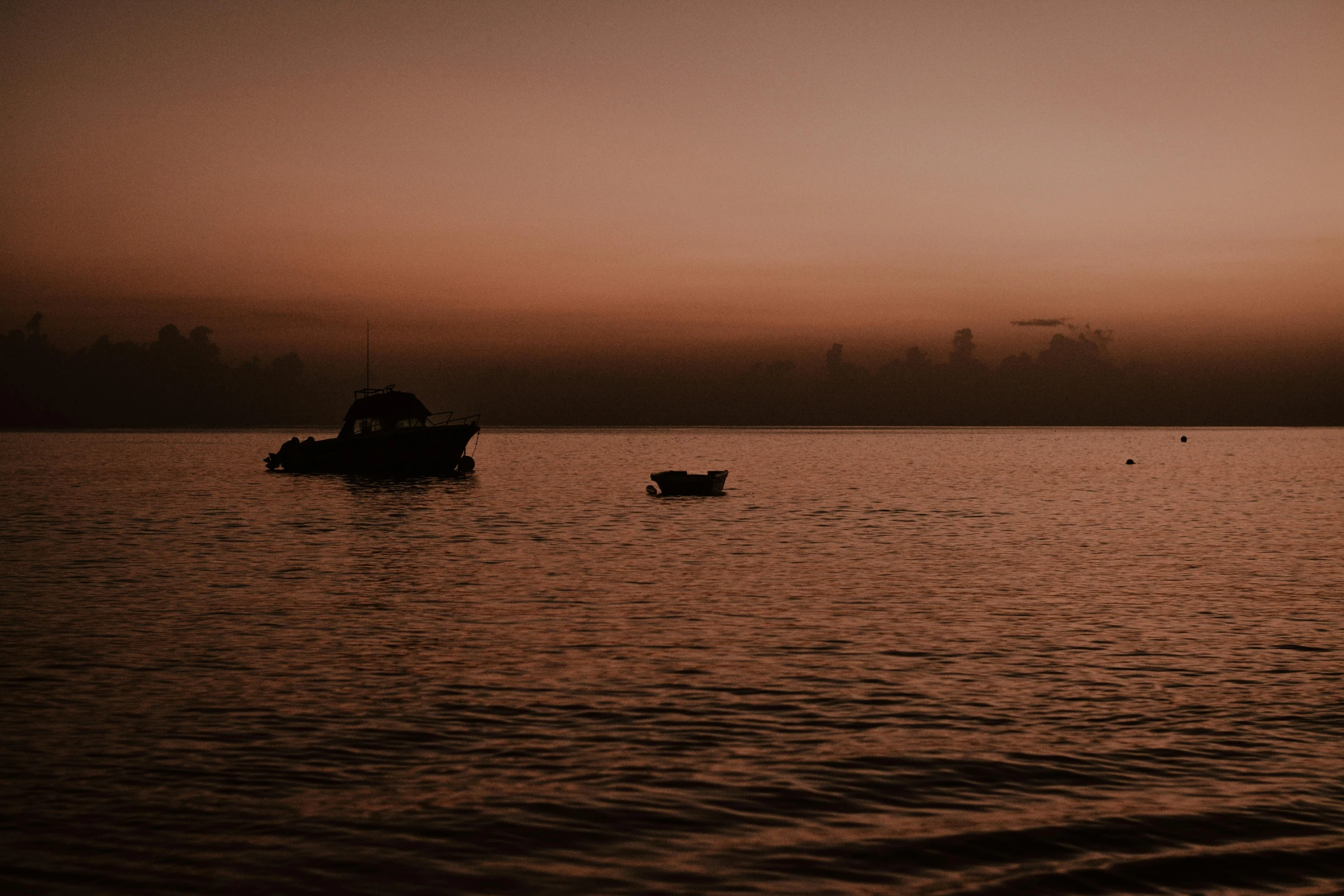 boats in the water near one another during a sunset