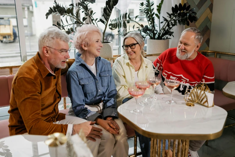 three elderly people sitting at a table together