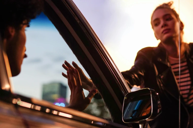 two women in a car waving and smiling