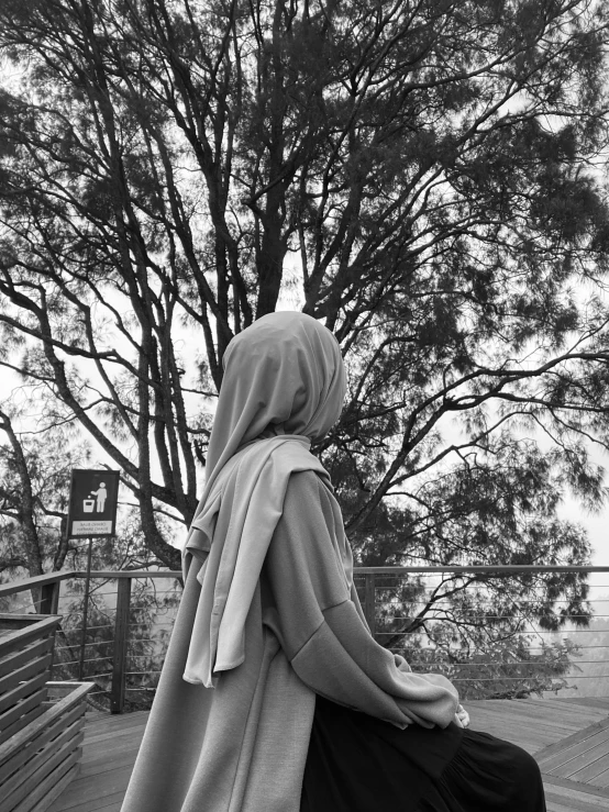 a person sitting on a bench near a tree