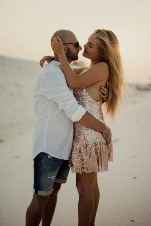 an affectionate couple cuddle on the beach