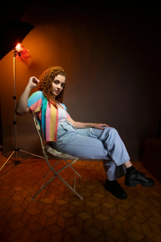 a red headed girl sits on a chair and looks up