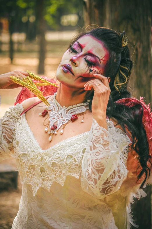 a woman with painted makeup is holding her necklace