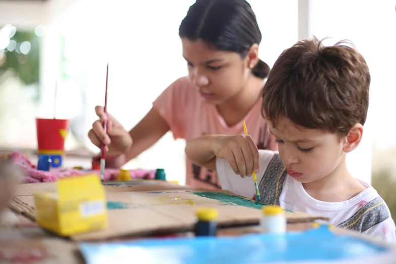 two people doing crafts at the table