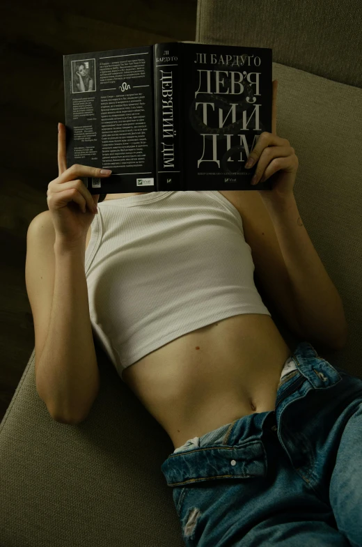 a woman sitting on a couch reading a book