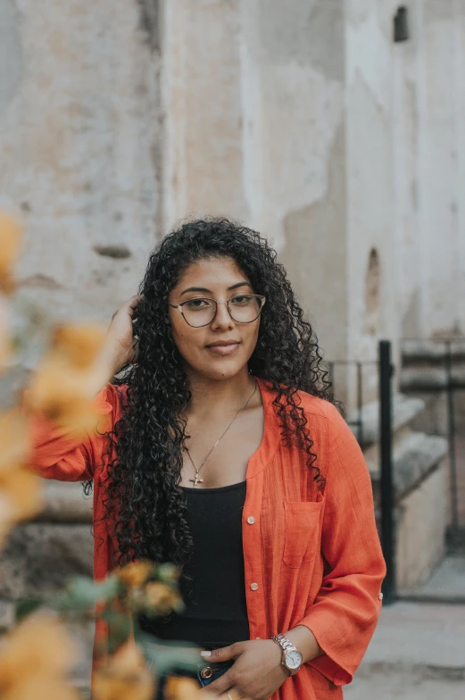 a person wearing glasses and an orange cardigan