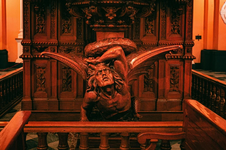 a carved statue of a demon on a bench