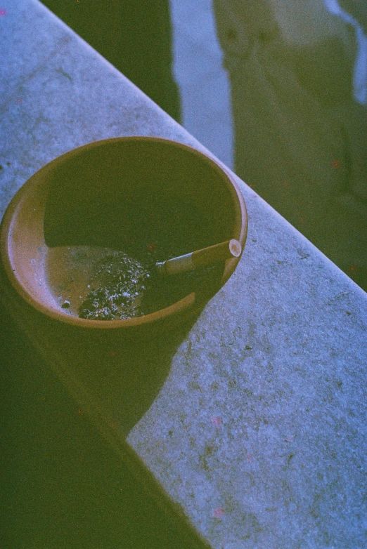 a bowl with water in it sitting on the sidewalk