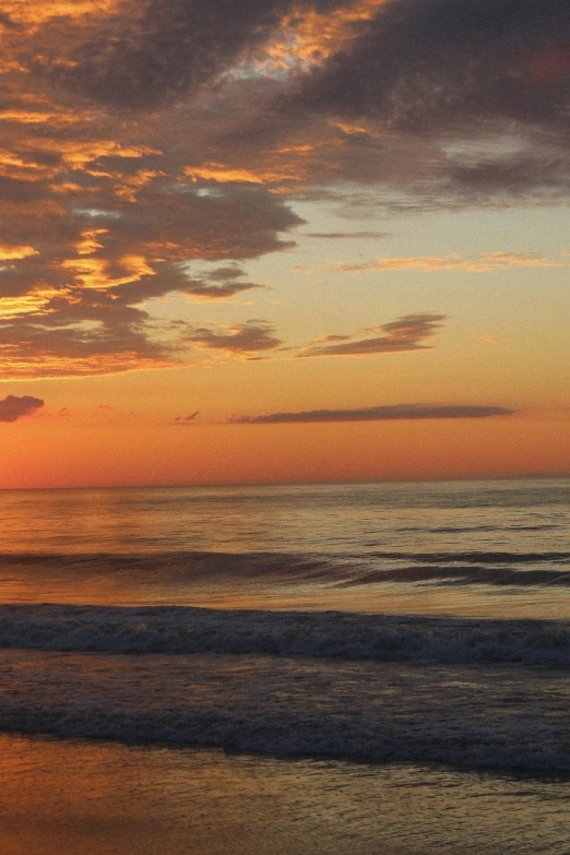 a sunset seen behind some water at the beach