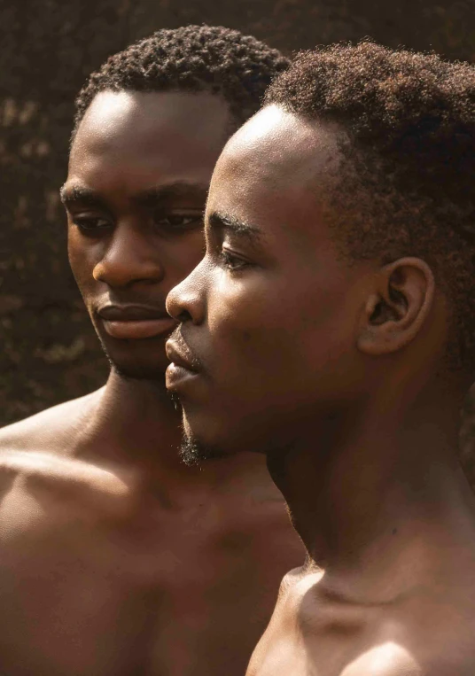 two african men wearing  shirts standing side by side