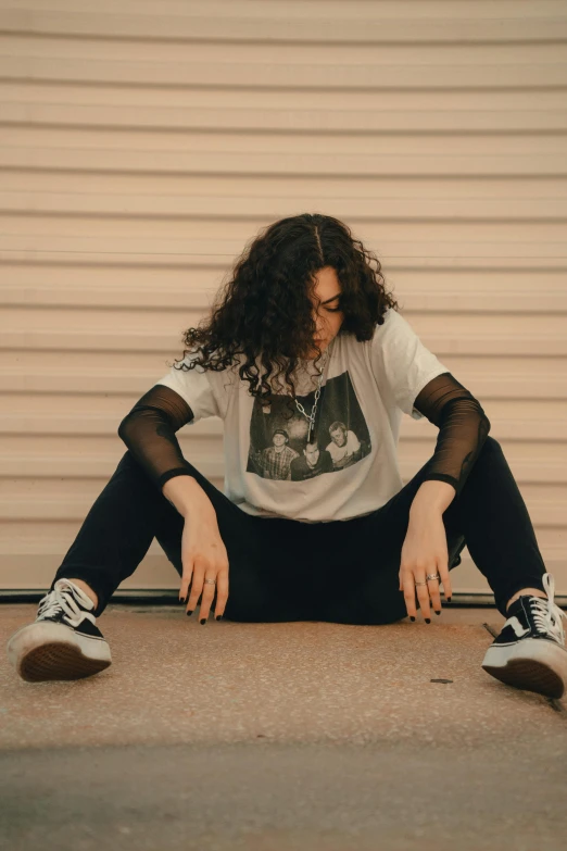 young woman sitting on the curb, looking sad