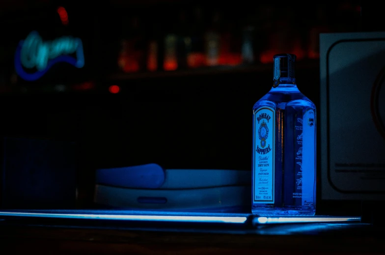 a bottle on a counter with an electric light in front of it
