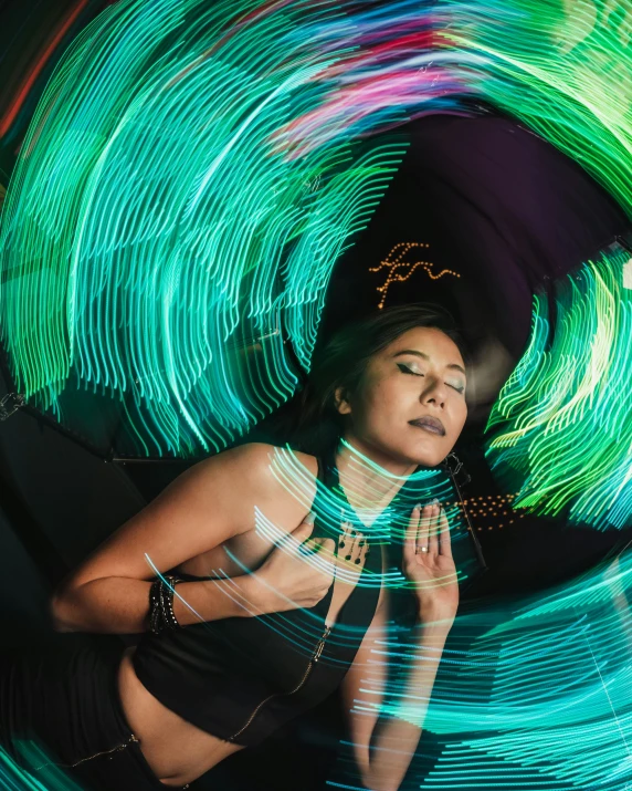 a woman posing with a spinning colored object in her hands