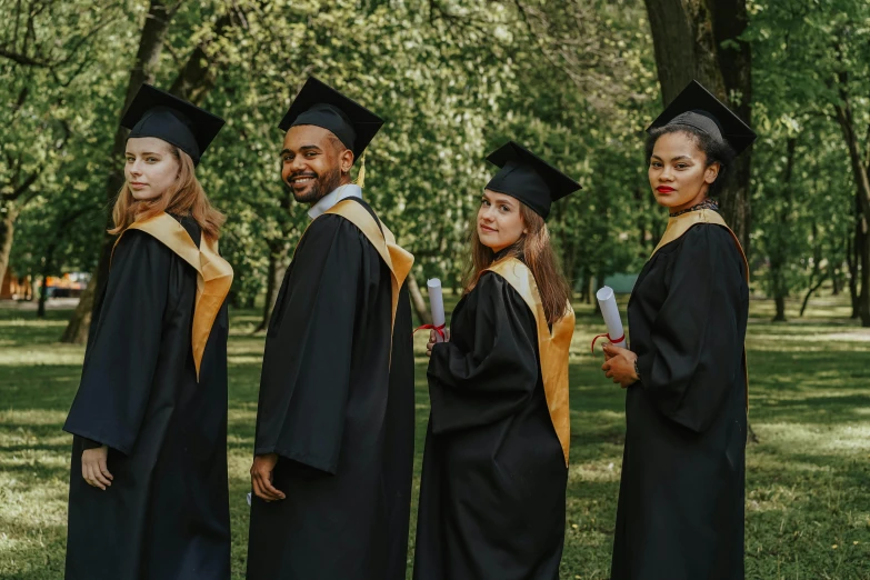 a group of three people in graduation robes