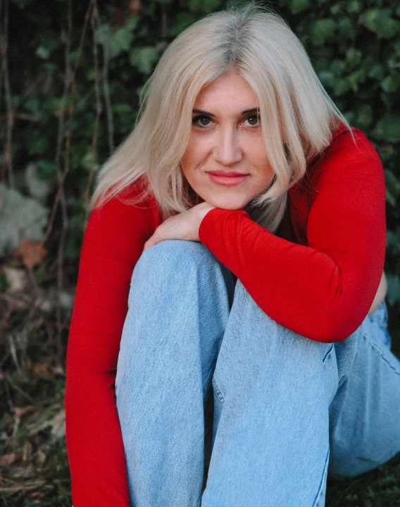 a person sitting on some grass and trees