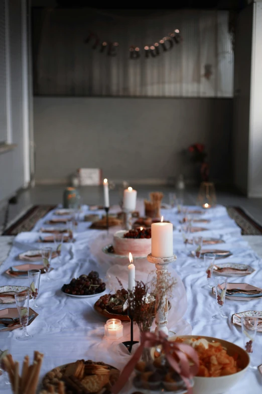 several plates on a table with candles and food