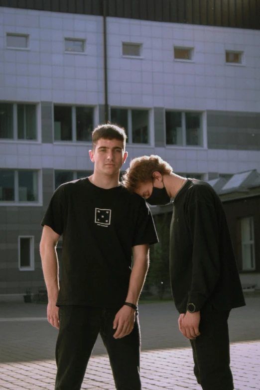 a couple of men standing next to each other in front of a building