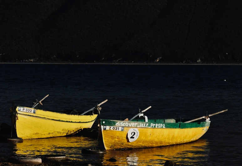 two boats floating in the water with sticks on them