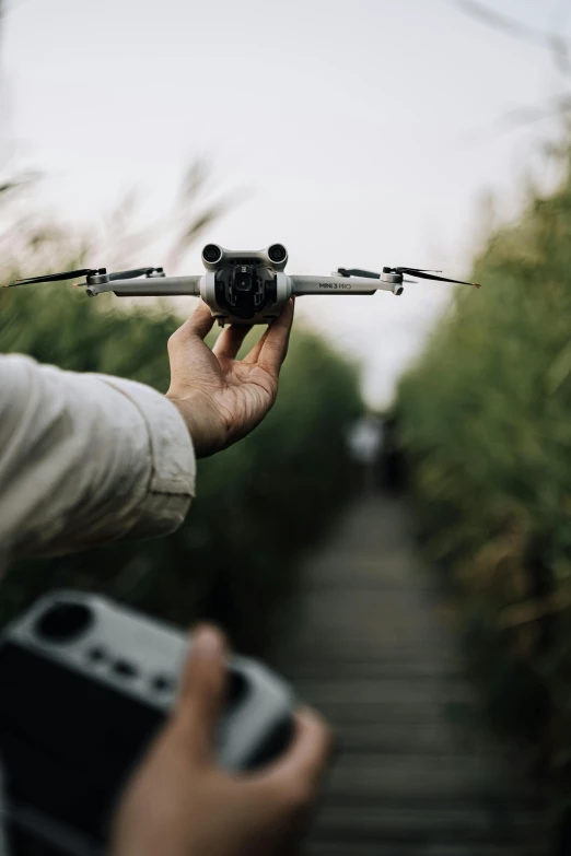 a man holding a tiny plane model with a camera