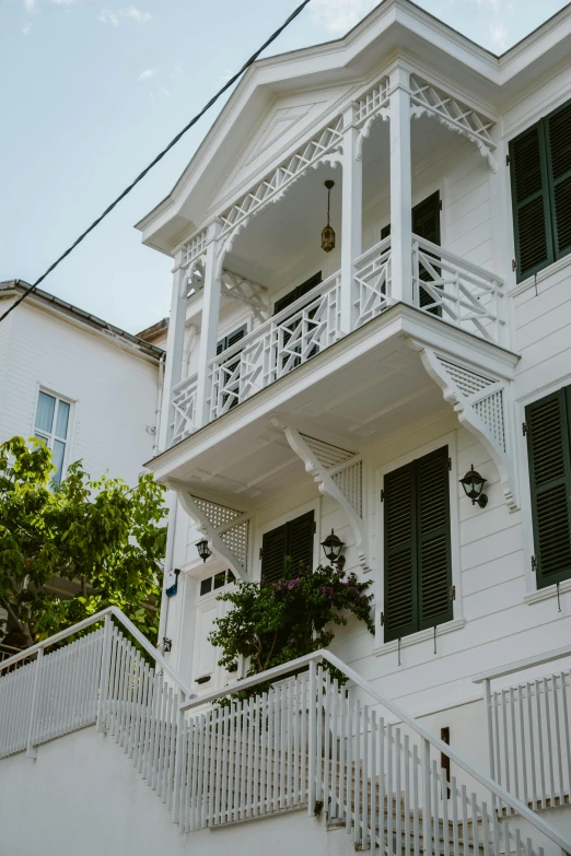 the front of a white house with windows and balconies