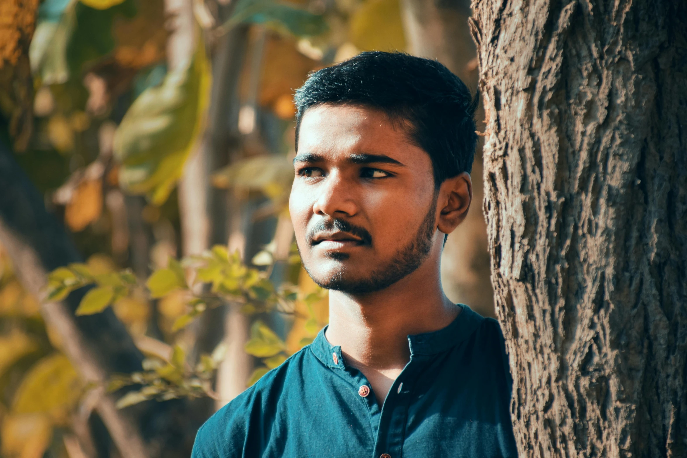 a man standing next to a tree with a big smile on his face