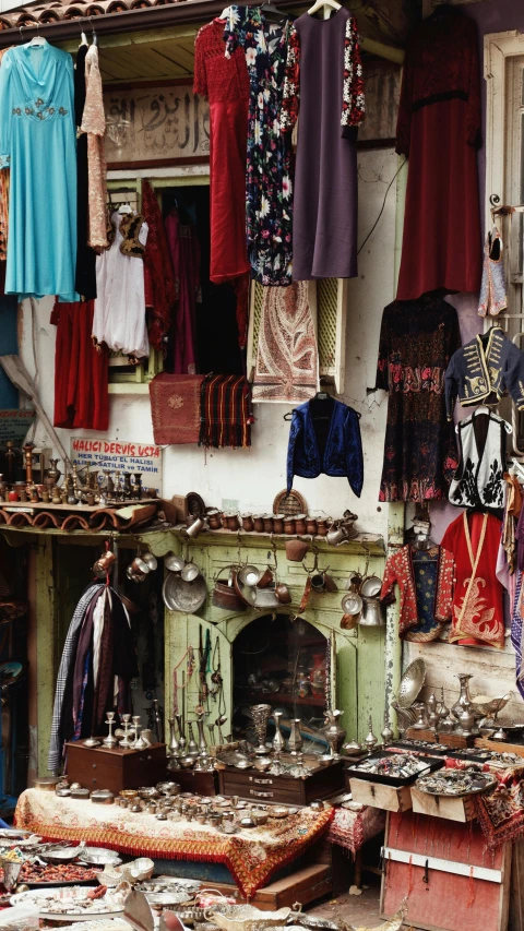 an outdoor market in the country has clothes hanging