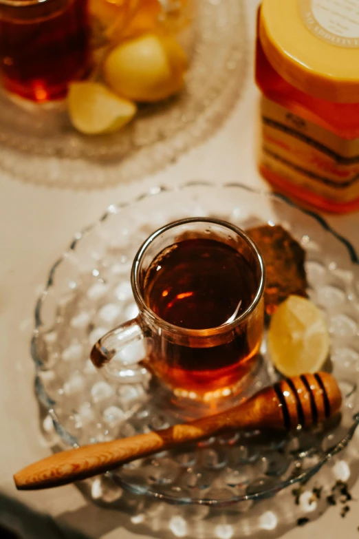 a tea cup sitting on top of a plate next to sliced lemons