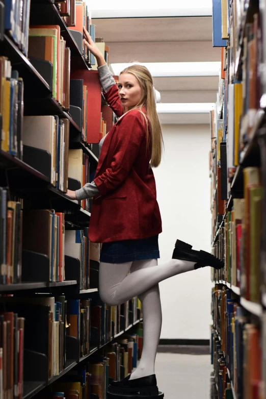 a woman in a liry looks for books on the shelves