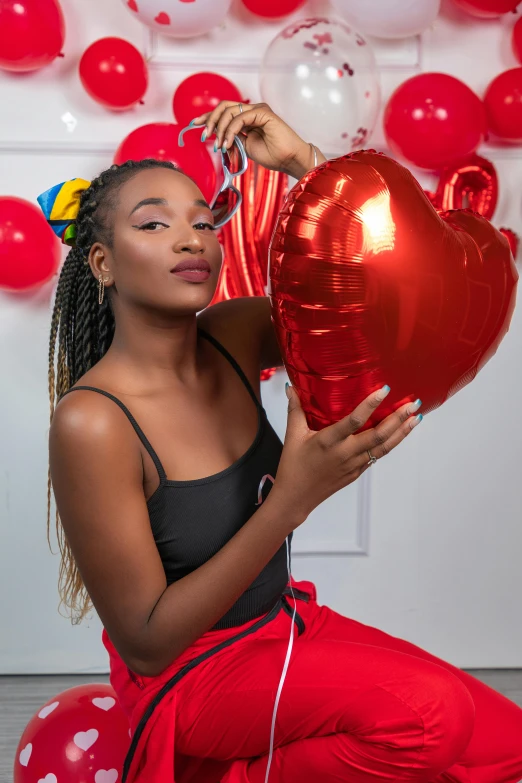 a girl holding red balloons and a large heart