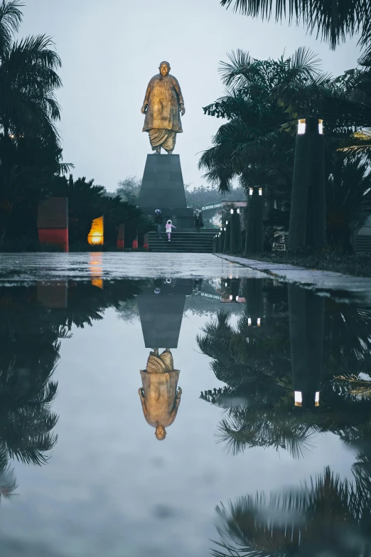 two golden statues with lit candles on the ground