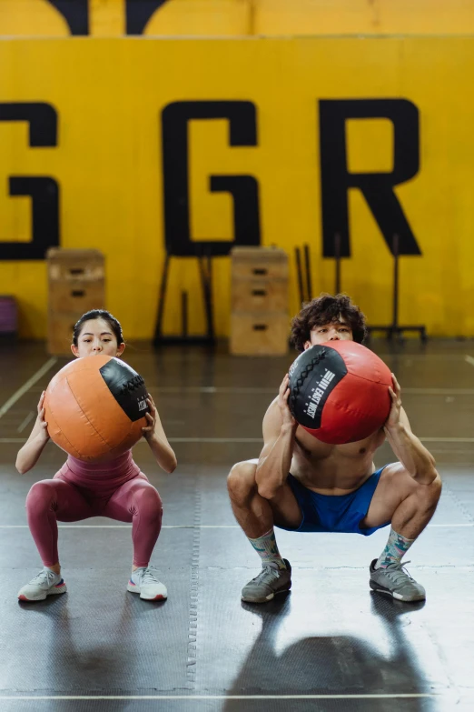 people doing exercises in a gym with balls